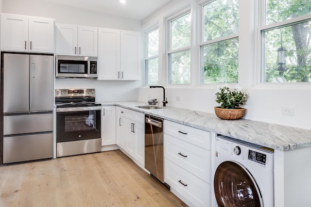 36 Pearl St Unit 3, Provincetown, MA 02657 - kitchen featuring stainless steel appliances, washer / clothes dryer, a sink, and healthy amount of natural light