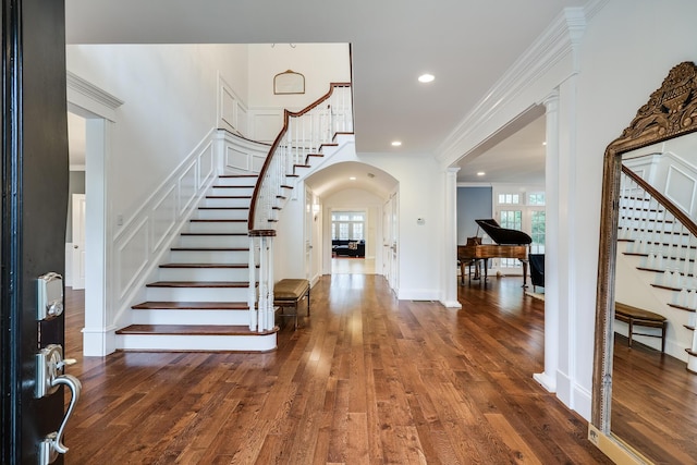 entryway featuring decorative columns, dark hardwood / wood-style floors, and crown molding