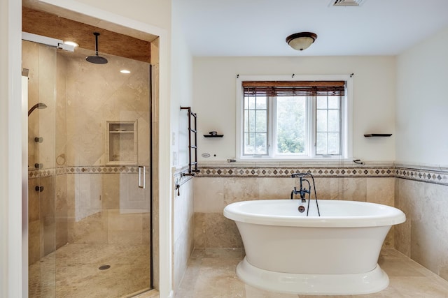 bathroom with tile walls, tile patterned floors, and separate shower and tub