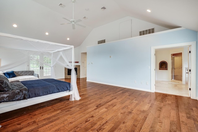 bedroom with hardwood / wood-style floors, high vaulted ceiling, and ceiling fan