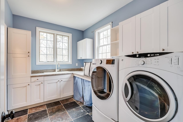 washroom with cabinets, sink, and washing machine and dryer