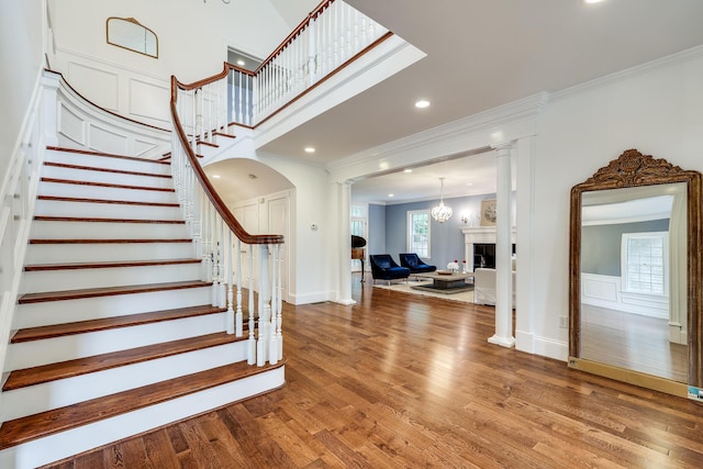 entryway with hardwood / wood-style floors, ornamental molding, and ornate columns