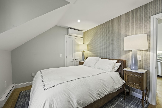 bedroom with lofted ceiling, hardwood / wood-style flooring, a wall unit AC, and a baseboard heating unit