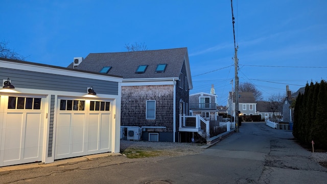 view of home's exterior with an outbuilding, central AC, and a garage