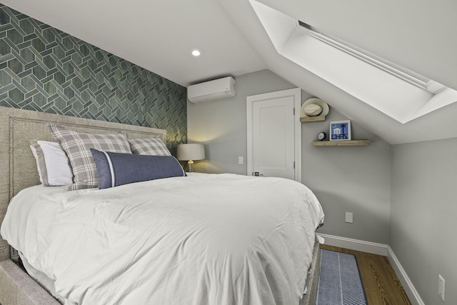 bedroom with hardwood / wood-style flooring, an AC wall unit, and vaulted ceiling with skylight