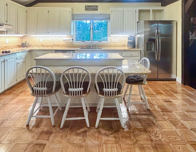 28 Brook St, Plympton, MA 02367 - kitchen with stainless steel refrigerator with ice dispenser, a sink, a center island, white cabinets, and a breakfast bar area