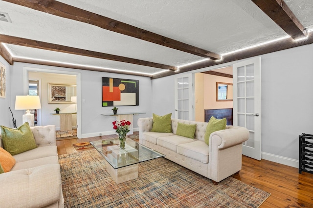 28 Brook St, Plympton, MA 02367 - living room with french doors, wood-type flooring, beamed ceiling, baseboards, and a textured ceiling