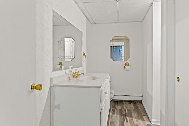 28 Brook St, Plympton, MA 02367 - bathroom featuring a baseboard radiator, vanity, toilet, wood finished floors, and a paneled ceiling