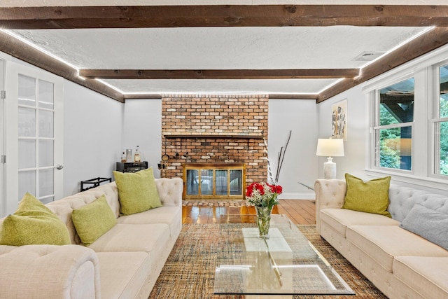 28 Brook St, Plympton, MA 02367 - living area featuring beamed ceiling, wood finished floors, and a brick fireplace