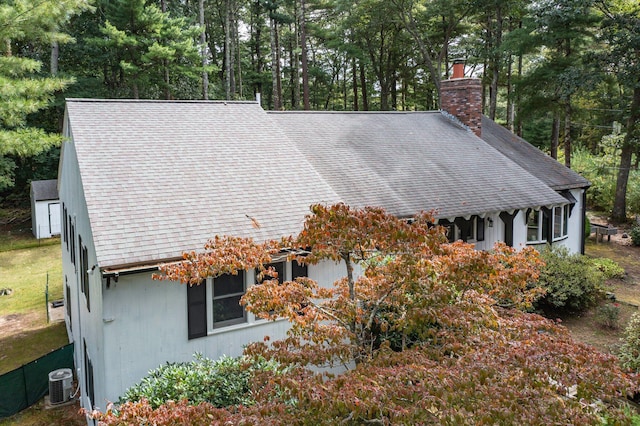 28 Brook St, Plympton, MA 02367 - view of side of home featuring a chimney, central AC unit, roof with shingles, and view of scattered trees