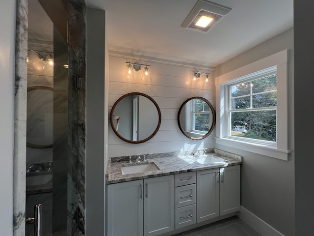 bathroom with walk in shower, vanity, and tile patterned flooring