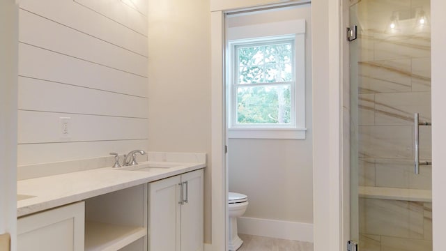 bathroom with vanity, toilet, a healthy amount of sunlight, and walk in shower