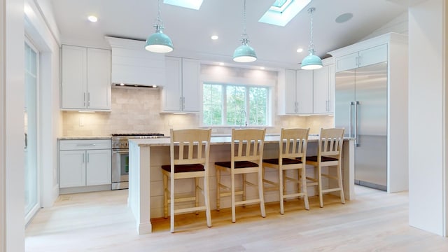 kitchen with a center island, high end appliances, and white cabinets