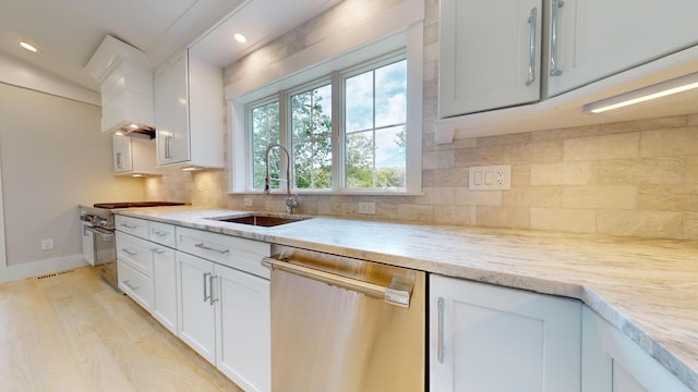 kitchen with backsplash, white cabinets, light stone countertops, and appliances with stainless steel finishes