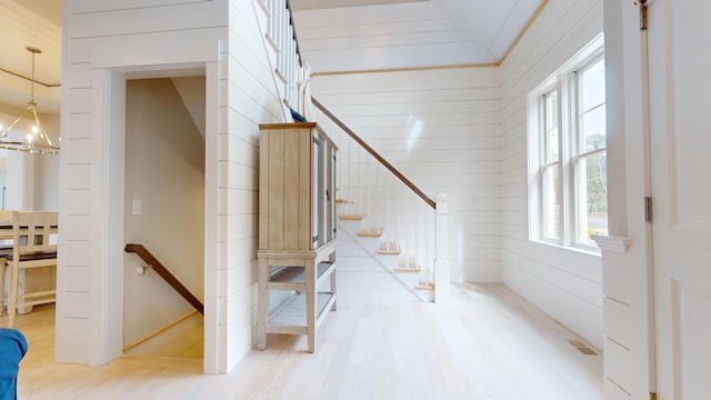 staircase featuring a chandelier and hardwood / wood-style floors