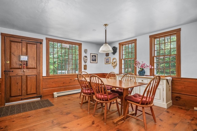 181 Stony Brook Rd, Brewster, MA 02631 - dining room featuring a baseboard radiator, wainscoting, hardwood / wood-style flooring, and wooden walls