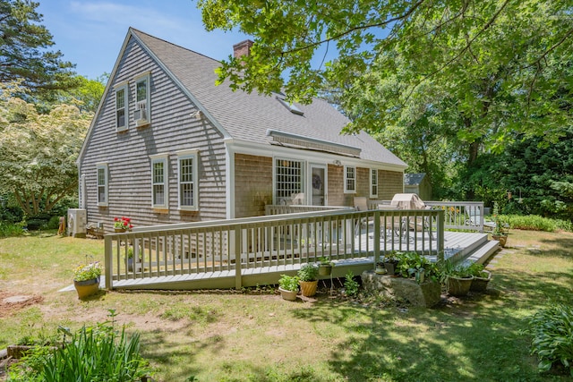 181 Stony Brook Rd, Brewster, MA 02631 - rear view of house featuring roof with shingles, a chimney, a wooden deck, and a lawn