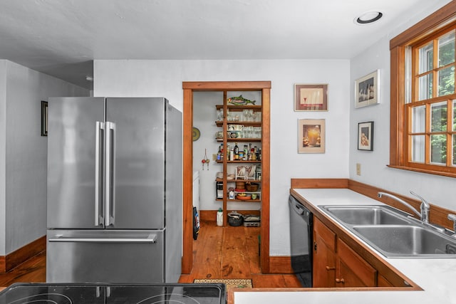 181 Stony Brook Rd, Brewster, MA 02631 - kitchen with freestanding refrigerator, black dishwasher, dark wood finished floors, light countertops, and brown cabinets