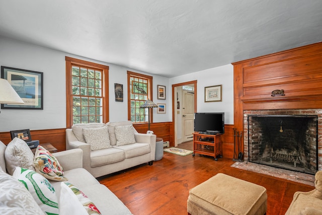 181 Stony Brook Rd, Brewster, MA 02631 - living room with wainscoting, a brick fireplace, wood finished floors, and wooden walls