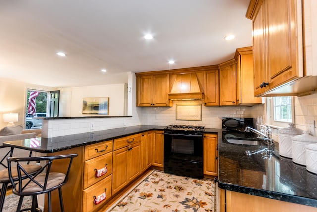 15 Mirror Brook Rd, West Yarmouth, MA 02673 - kitchen with black appliances, custom exhaust hood, a peninsula, brown cabinetry, and a kitchen bar