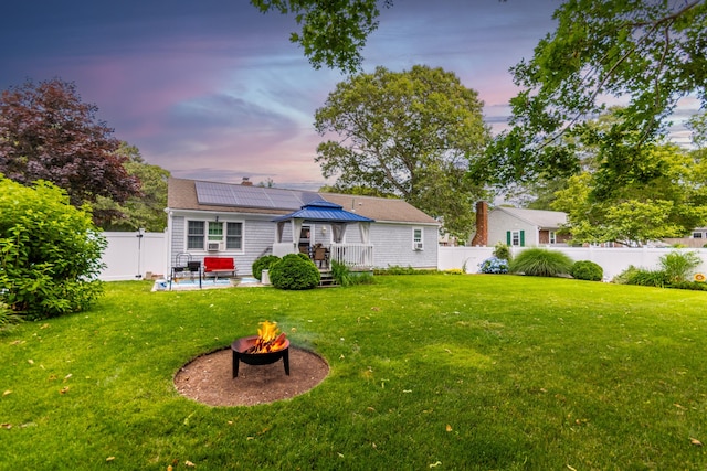 15 Mirror Brook Rd, West Yarmouth, MA 02673 - back of house at dusk featuring a gazebo, an outdoor fire pit, a wooden deck, and a fenced backyard