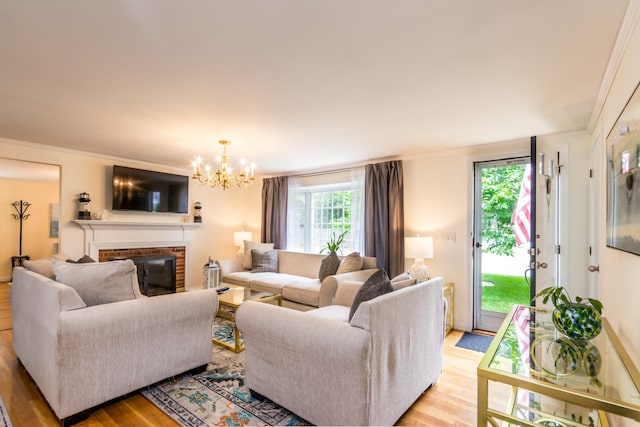 15 Mirror Brook Rd, West Yarmouth, MA 02673 - living room featuring light wood-style flooring, a chandelier, a brick fireplace, and crown molding