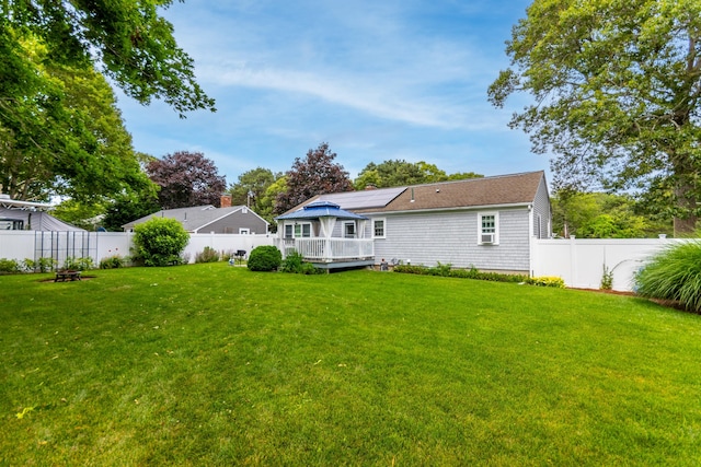 15 Mirror Brook Rd, West Yarmouth, MA 02673 - rear view of house featuring a deck, a fenced backyard, and solar panels