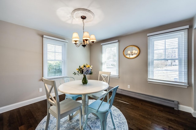 dining area featuring a chandelier, baseboard heating, baseboards, and dark wood finished floors