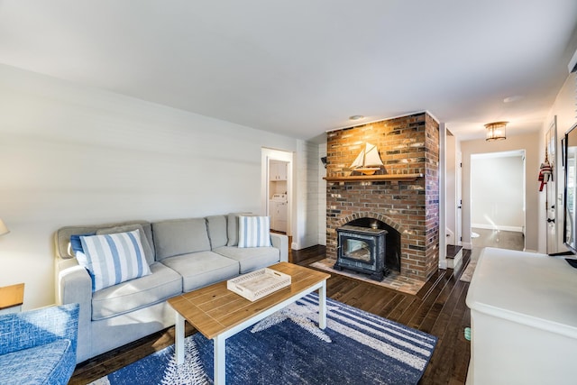 living area with dark wood-style floors, washer / dryer, and baseboards