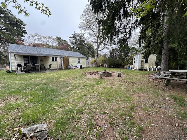 39 Naushon Rd, Dennis Port, MA 02639 - view of yard featuring an outdoor fire pit, a patio area, an outdoor structure, and a storage unit