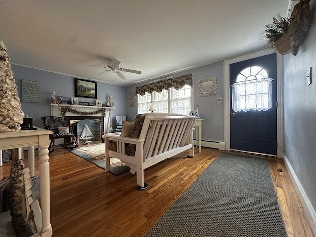 39 Naushon Rd, Dennis Port, MA 02639 - entryway featuring a baseboard heating unit, wood finished floors, ornamental molding, ceiling fan, and a glass covered fireplace