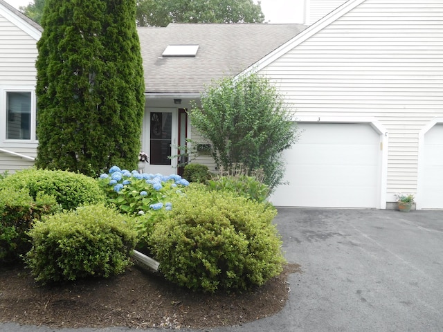 3 Executive Dr, Mashpee, MA 02649 - view of exterior entry featuring a garage, a shingled roof, and asphalt driveway