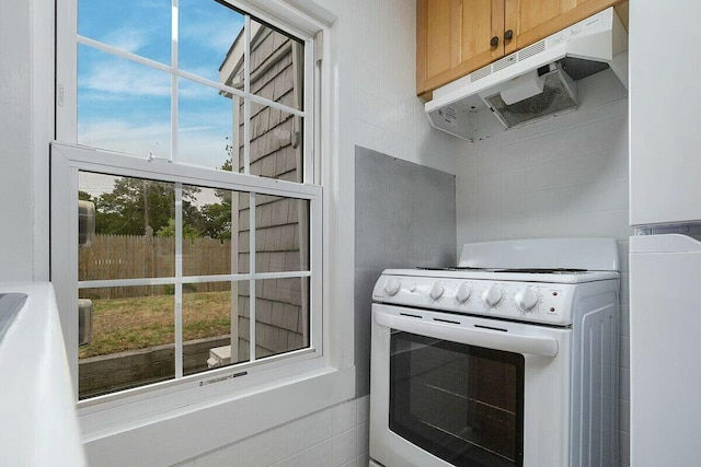 kitchen featuring plenty of natural light, white electric stove, and light brown cabinetry