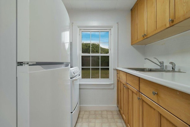 clothes washing area with cabinets, sink, and independent washer and dryer