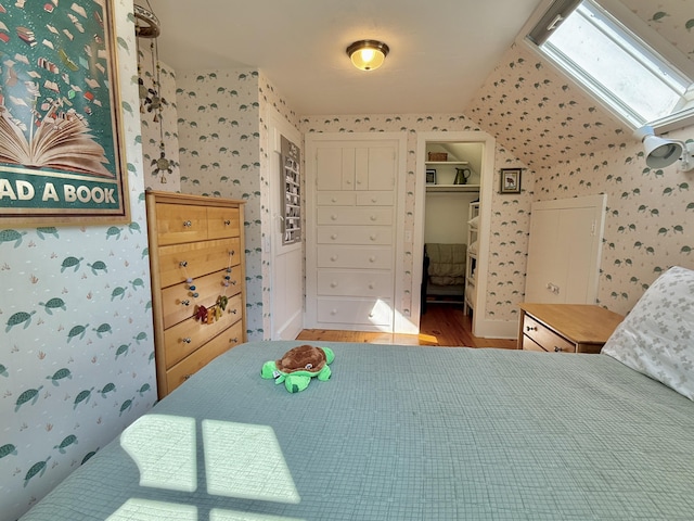 625 Bridge Rd, Eastham, MA 02642 - bedroom with wallpapered walls, wood finished floors, a closet, and a skylight