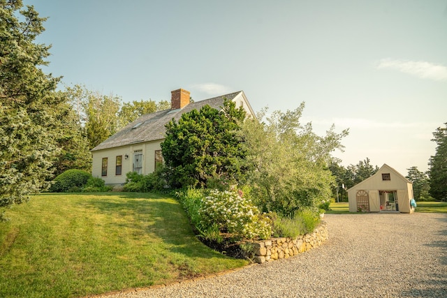 625 Bridge Rd, Eastham, MA 02642 - view of property exterior with a chimney, a lawn, and an outbuilding