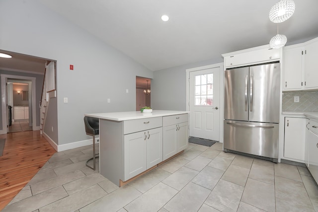 240 Oak St, Centerville, MA 02632 - kitchen with freestanding refrigerator, lofted ceiling, light countertops, decorative backsplash, and white cabinetry