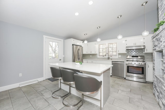 240 Oak St, Centerville, MA 02632 - kitchen with stainless steel appliances, under cabinet range hood, a sink, backsplash, and lofted ceiling