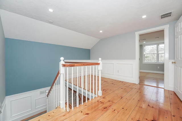 240 Oak St, Centerville, MA 02632 - stairs featuring hardwood / wood-style floors, wainscoting, a decorative wall, and vaulted ceiling