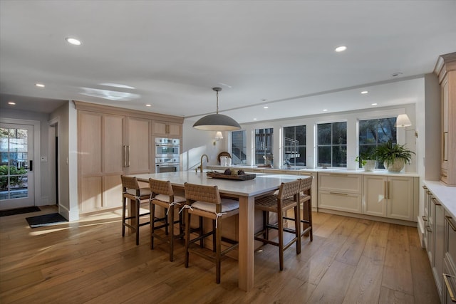 118 Driftwood Ln, South Yarmouth, MA 02664 - kitchen featuring light countertops, recessed lighting, light wood finished floors, a kitchen breakfast bar, and an island with sink
