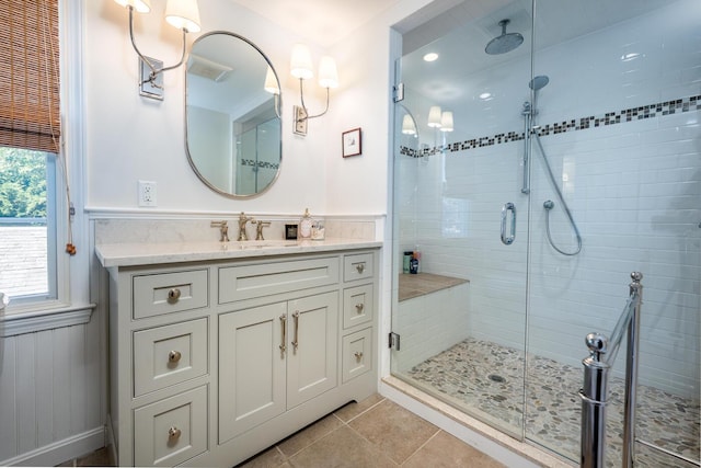 bathroom featuring a shower with shower door, vanity, and tile patterned flooring