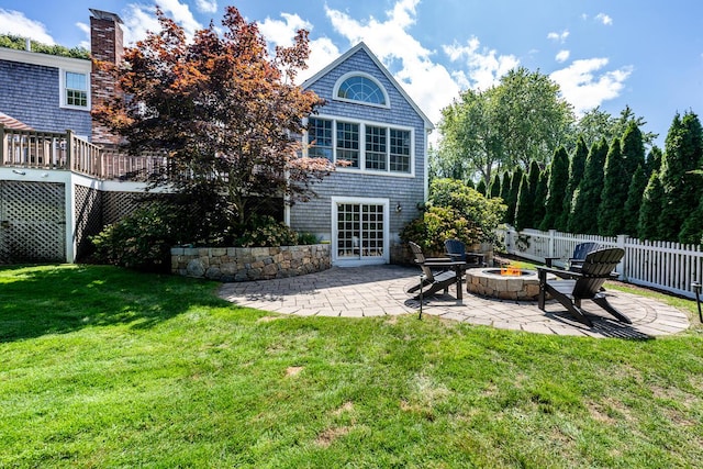 back of house with a patio, an outdoor fire pit, a deck, and a yard