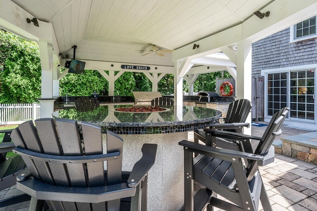 view of patio with exterior kitchen, a gazebo, an outdoor wet bar, and ceiling fan