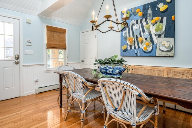 dining space with hardwood / wood-style floors, a baseboard radiator, and lofted ceiling