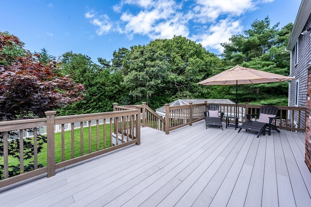 wooden deck featuring a lawn