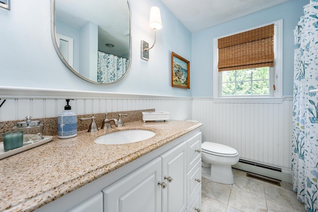 bathroom featuring a baseboard radiator, toilet, and vanity