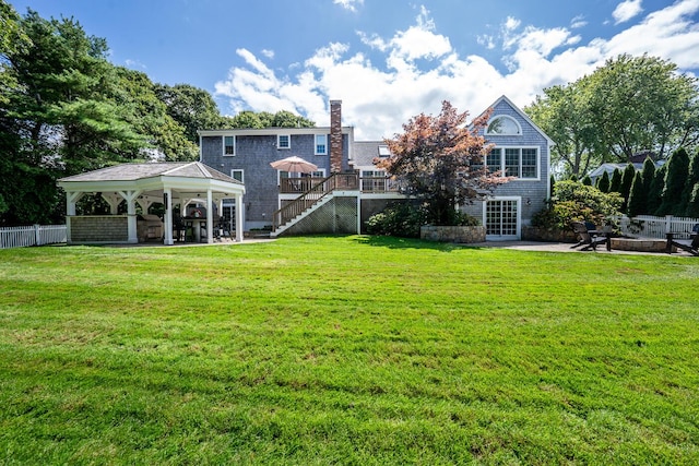 back of house featuring a wooden deck, a patio area, a gazebo, and a yard