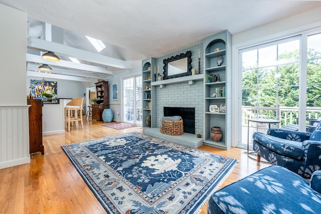 living room featuring a skylight, a wealth of natural light, beam ceiling, and wood-type flooring