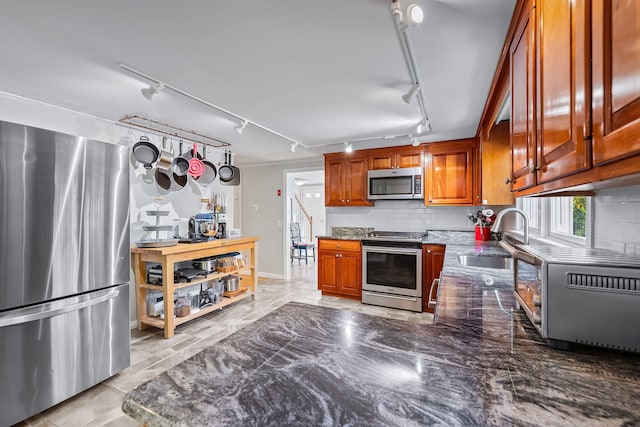 kitchen with stainless steel appliances, tasteful backsplash, sink, and dark stone counters