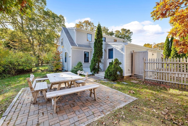 rear view of property featuring a patio and a lawn